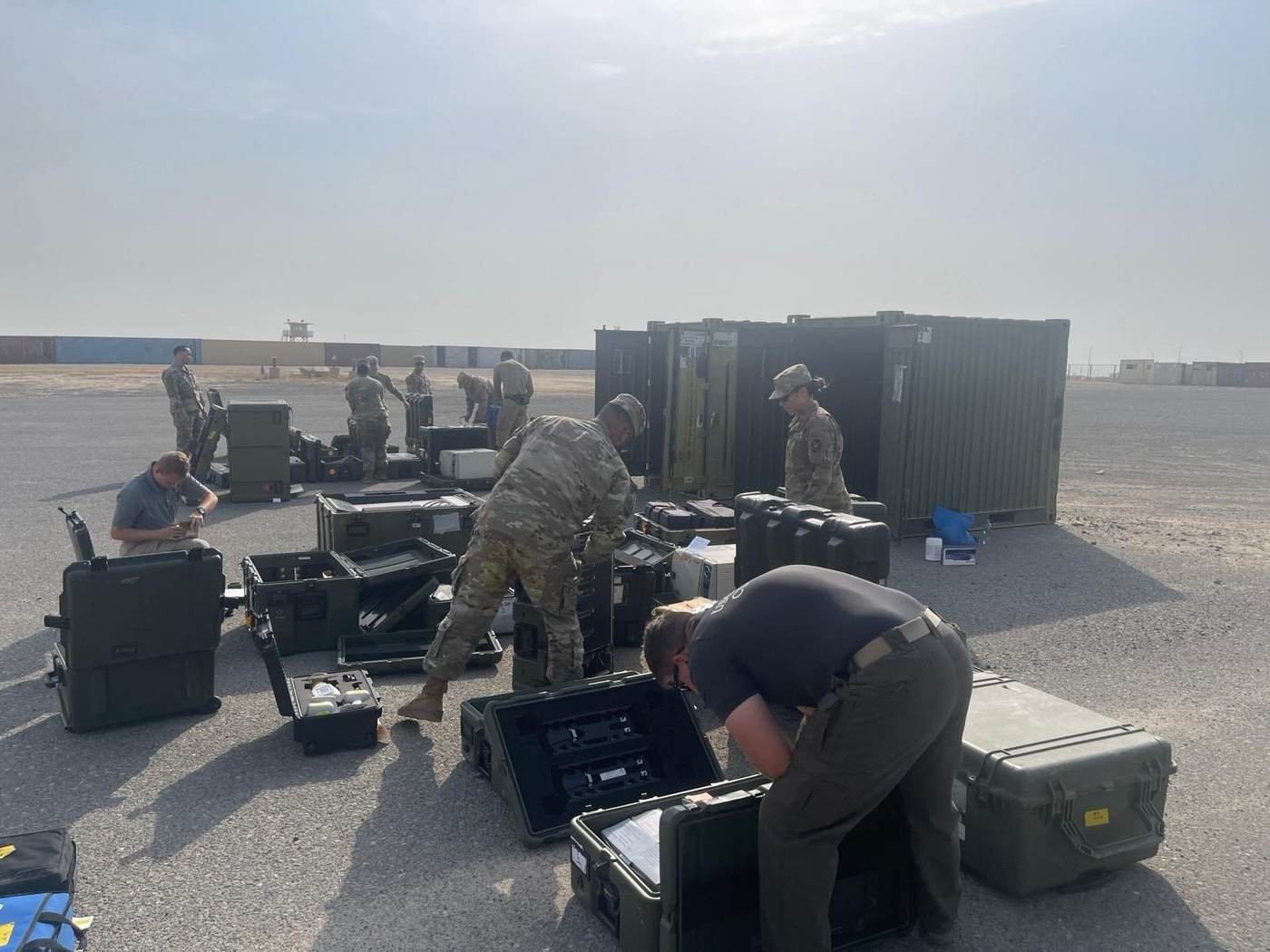 Team checking field inventory near shipping containers