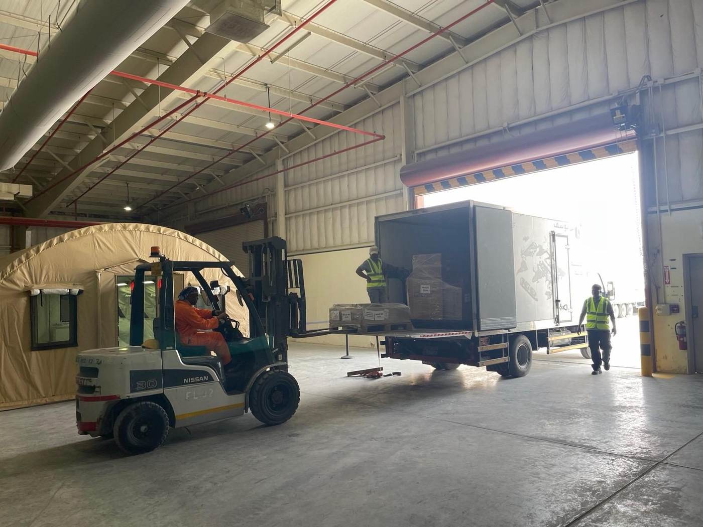 Forklift loading freight into a truck at a warehouse