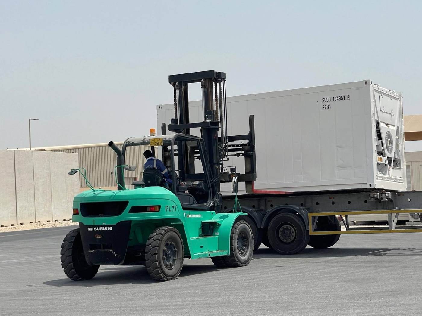 Forklift moving a large container during logistics operations