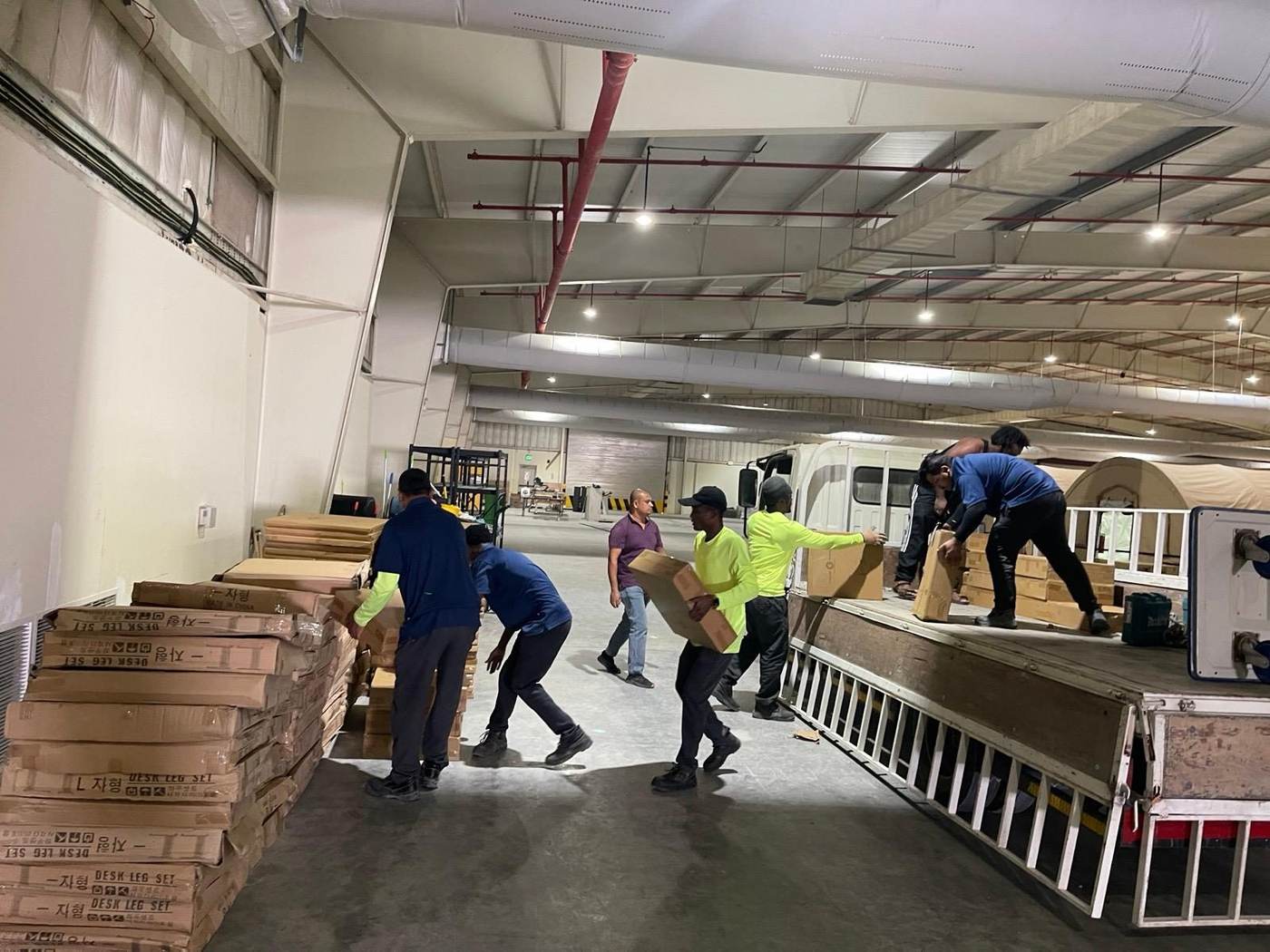 Team manually loading boxes from a truck into a warehouse